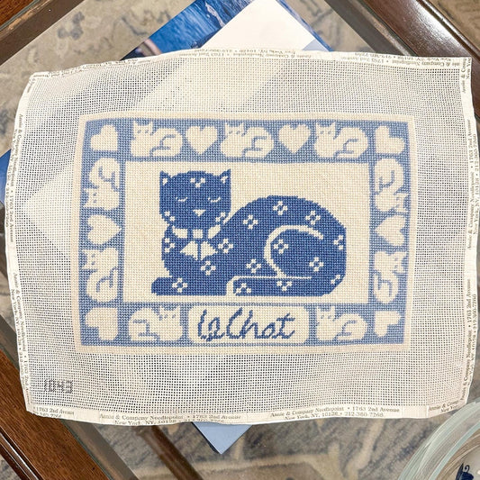 Embroidered fabric with blue cat design and 'La Chat' text on a white background.